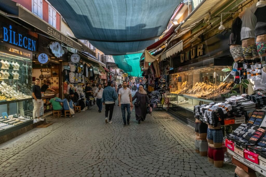 Vibrant market street scene in İzmir, Türkiye, showcasing diverse shops and pedestrians.